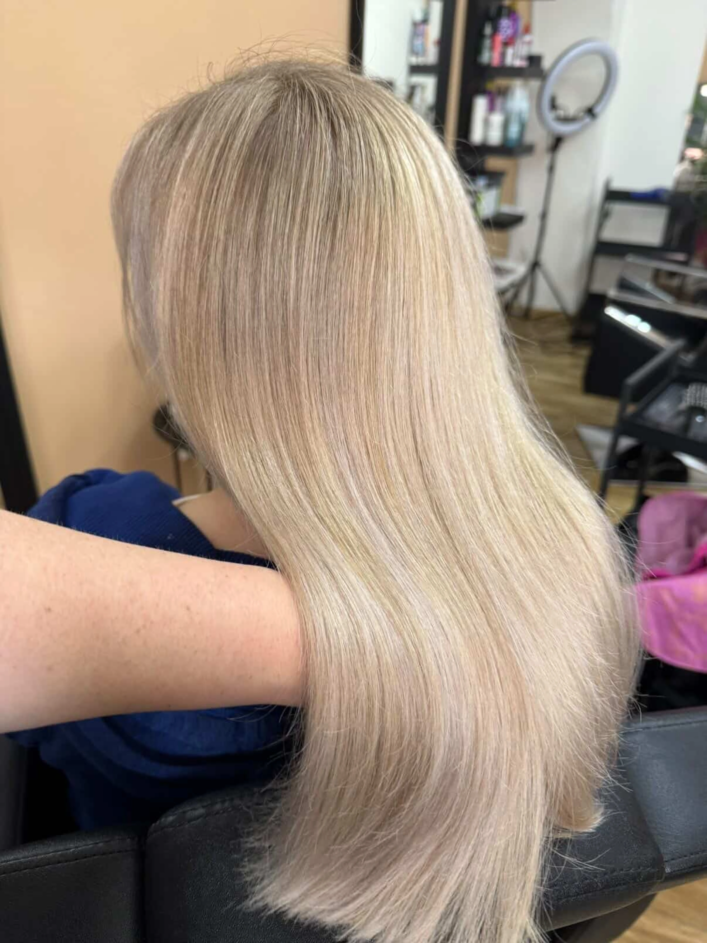 Dlouhé rovné světle blond vlasy zobrazené zezadu.