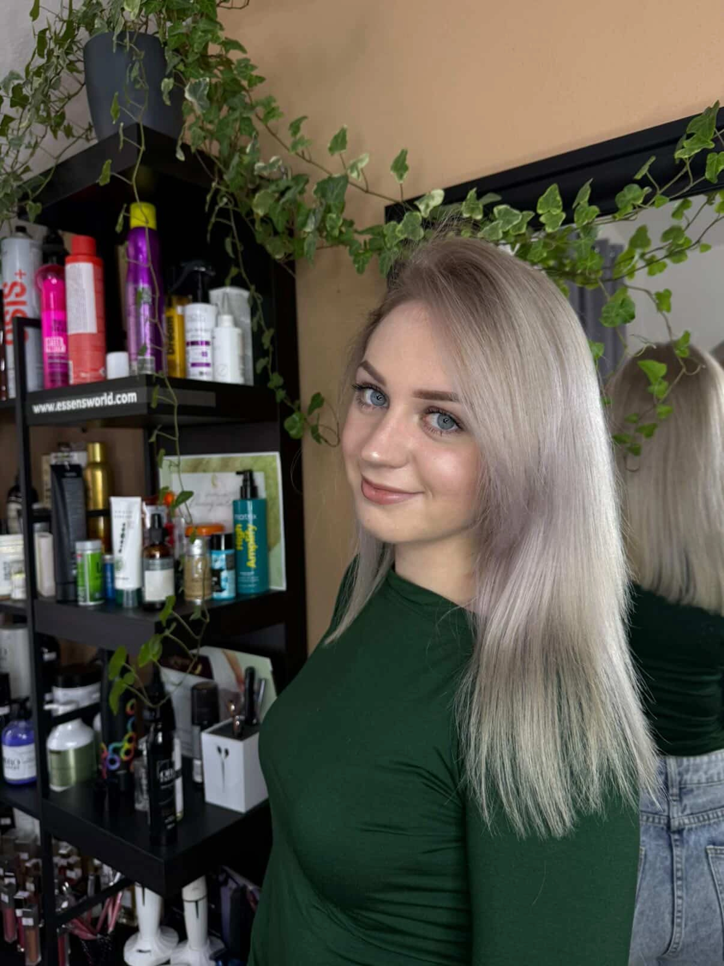Usměvavá mladá žena s popelavě blond barvením a rovným střihem.